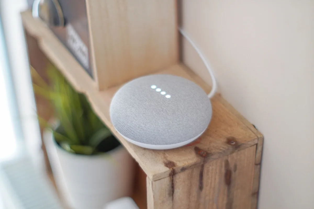 Smart speaker on wooden shelf in home setting