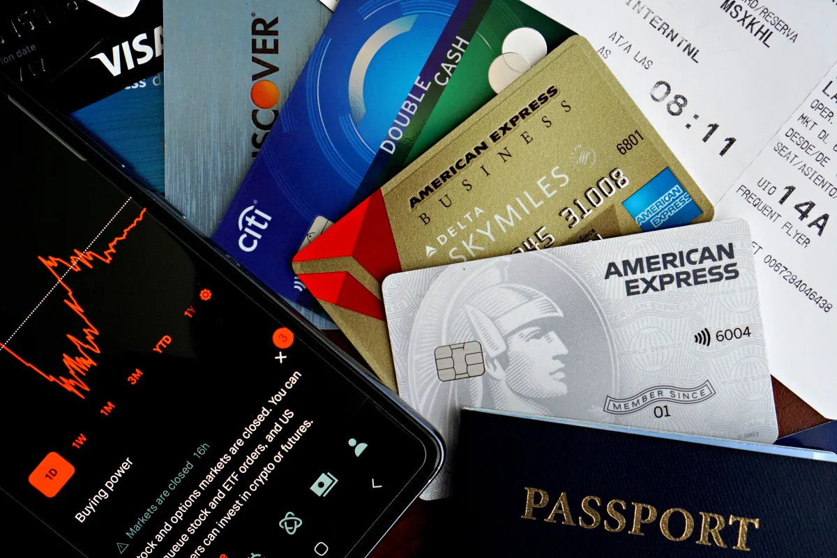 Flat lay of credit cards, passport, and phone — flight deal search tools 2026