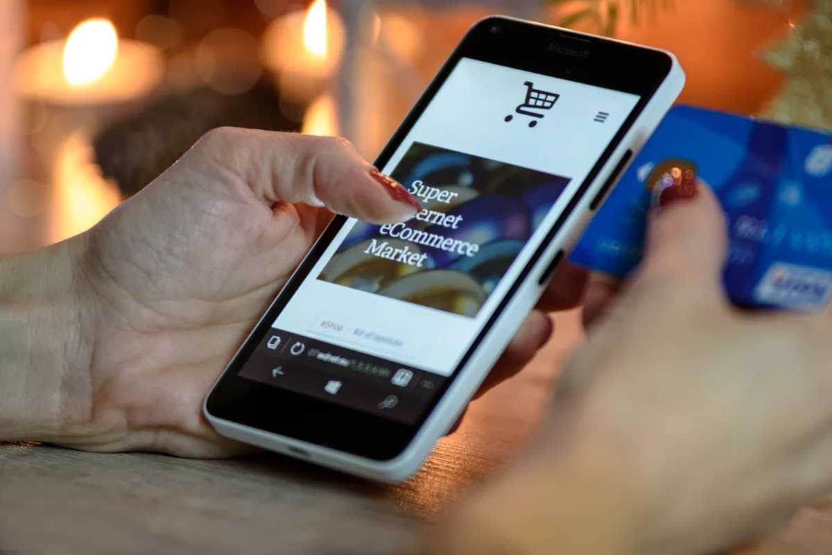 Person using laptop to shop online with credit card in hand