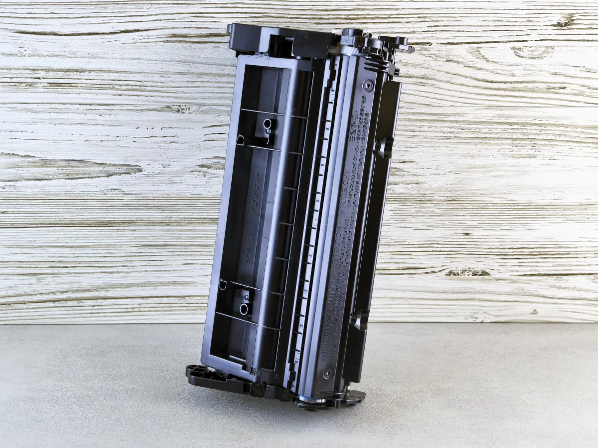 Black laser printer toner cartridge on wooden background