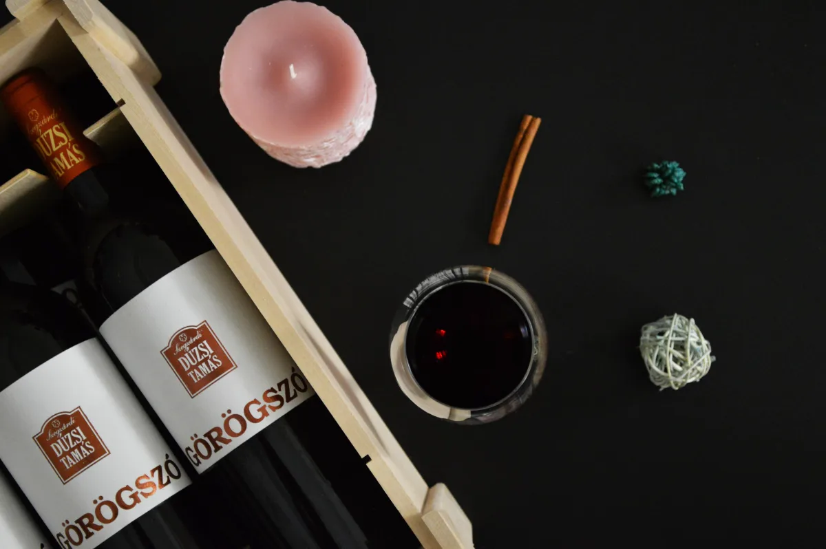 Flat lay of red wine bottles with candle on dark background